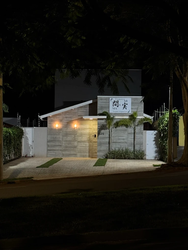 Fachada iluminada do Espaço MA & MI à noite.
